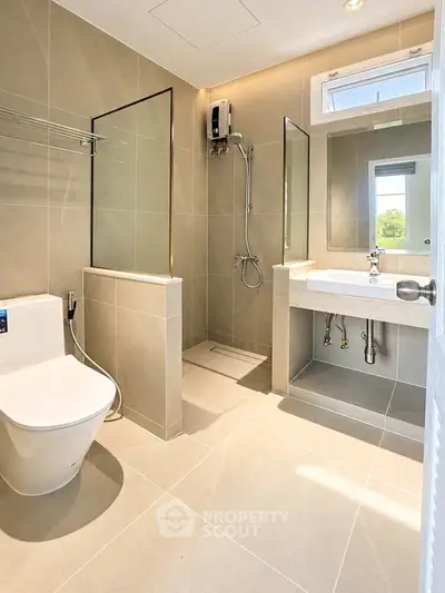 Modern bathroom with sleek fixtures and natural light, featuring a spacious shower and elegant design.