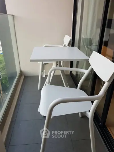 Chic balcony with modern white furniture and glass railing, perfect for relaxation.