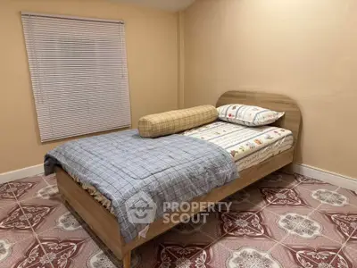 Cozy bedroom with stylish bed and patterned floor tiles, perfect for a restful retreat.