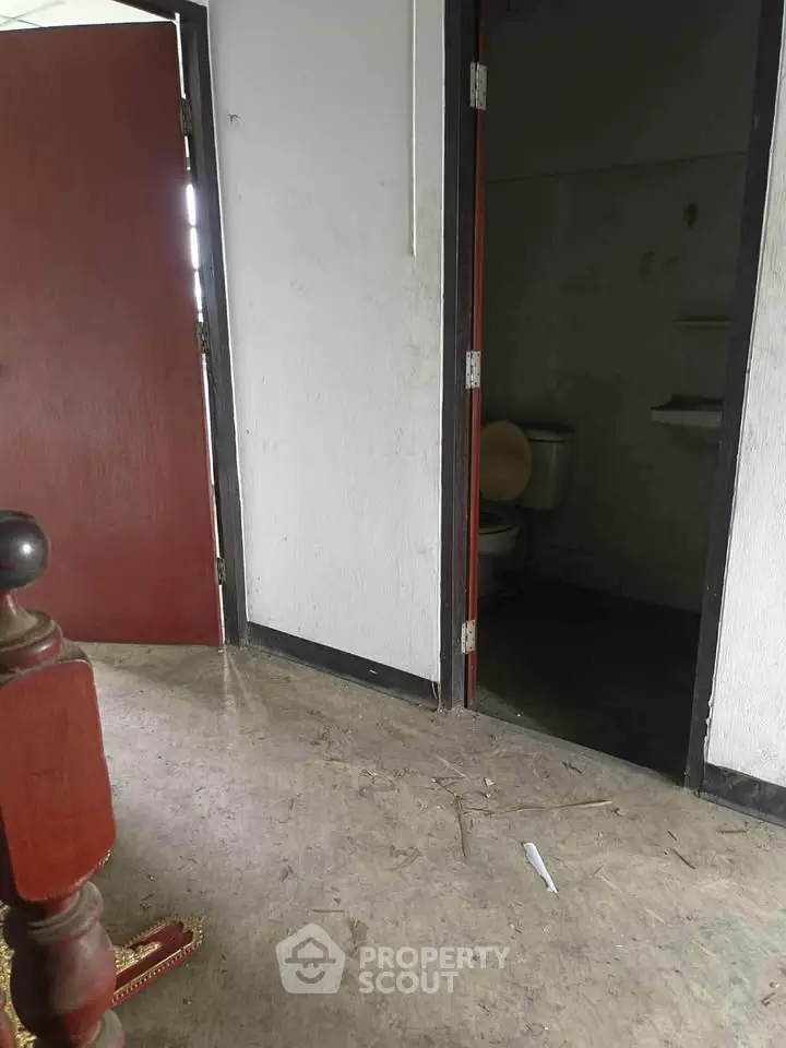 Basic interior with open door leading to a bathroom, showcasing simple design.