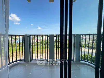 Spacious balcony with stunning view of lush greenery and clear blue sky.