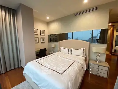 Luxurious bedroom with elegant decor and large window offering city views.