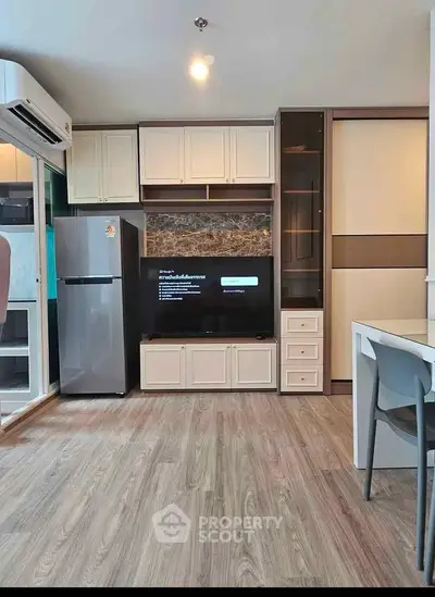 Modern living room with sleek furniture, built-in storage, and a flat-screen TV, perfect for urban living.