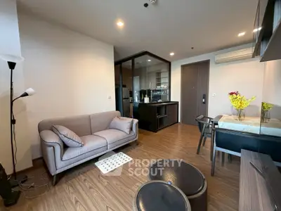 Modern living room with cozy sofa and stylish dining area in open-plan apartment.