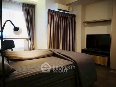 Cozy bedroom with modern decor, featuring a large bed, TV, and stylish curtains.