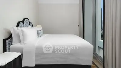 Elegant bedroom with modern decor and large window offering city view.