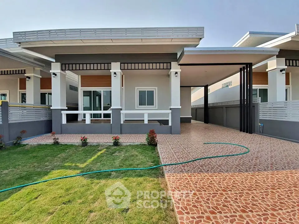 Modern single-story home with spacious driveway and manicured lawn