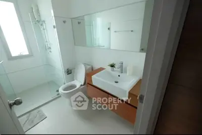 Modern bathroom with glass shower and sleek wooden vanity