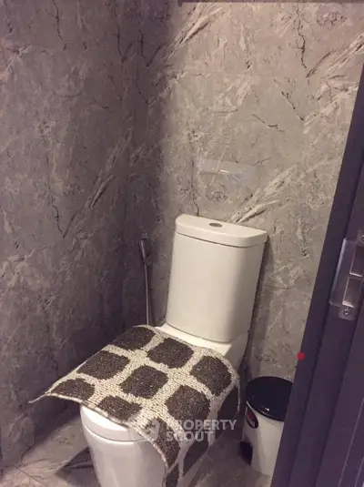 Modern bathroom with marble walls and sleek toilet design