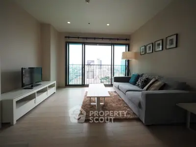 Spacious living room with modern decor and large windows offering city views.