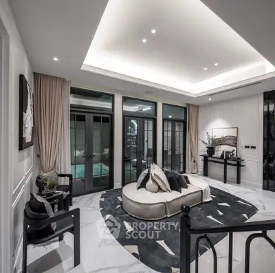 Luxurious modern living room with elegant decor and large windows overlooking a serene outdoor space.