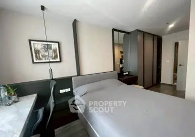 Modern bedroom with sleek design, featuring a comfortable bed, stylish desk, and ample storage space.