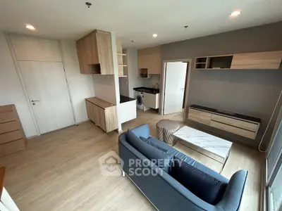 Modern living room with stylish furniture and open kitchen layout in a contemporary apartment.