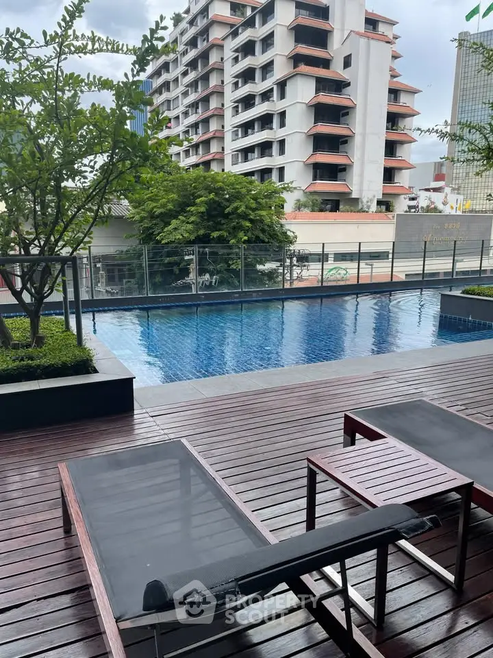 Luxurious poolside view with modern loungers and cityscape backdrop, perfect for relaxation and urban living.