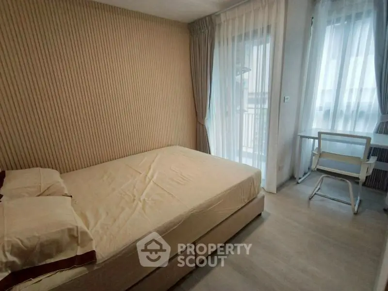 Cozy bedroom with natural light and modern decor, featuring a comfortable bed and a study desk by the window.