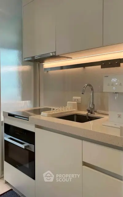 Modern kitchen with sleek cabinetry and built-in appliances, featuring a stylish countertop and sink.