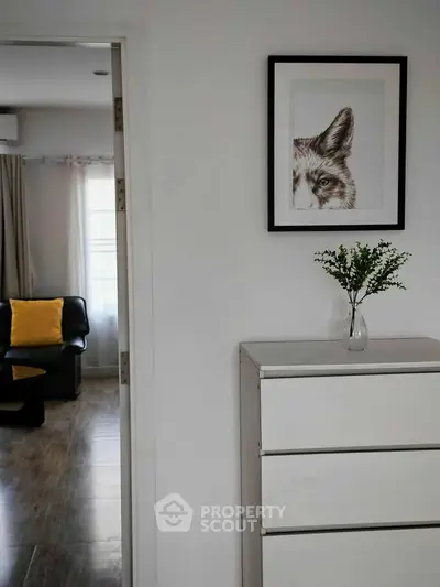 Modern interior with stylish decor, featuring a framed artwork and sleek furniture in a cozy living space.