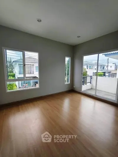 Spacious empty room with large windows and balcony access, offering abundant natural light and modern flooring.