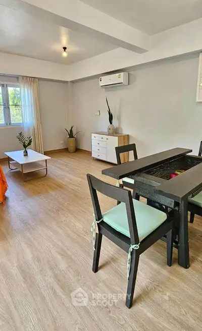 Spacious living room with modern furniture and air conditioning, perfect for relaxation and entertaining.