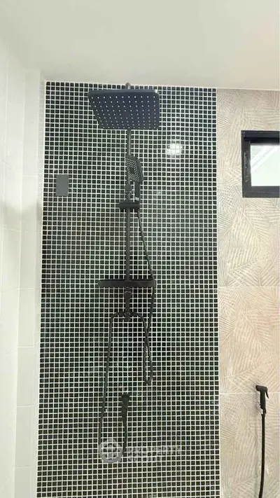 Modern bathroom with stylish black showerhead and mosaic tile wall design