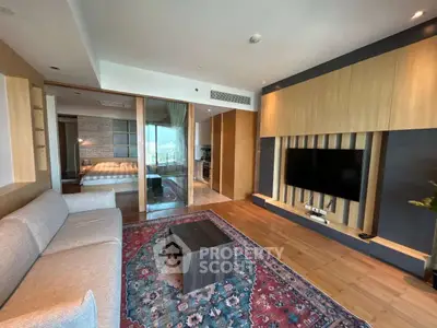 Modern living room with stylish decor and open view to bedroom and kitchen.