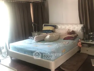 Cozy bedroom with plush bed and soft lighting, perfect for relaxation.