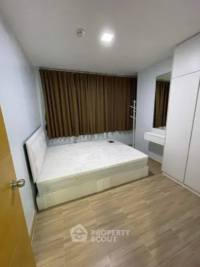 Cozy bedroom with modern design, featuring a comfortable bed and ample storage space.