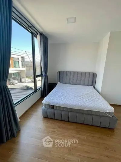 Bright bedroom with large window and modern bed in a stylish home.