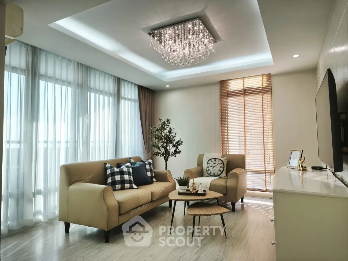 Elegant living room with modern chandelier and cozy seating area