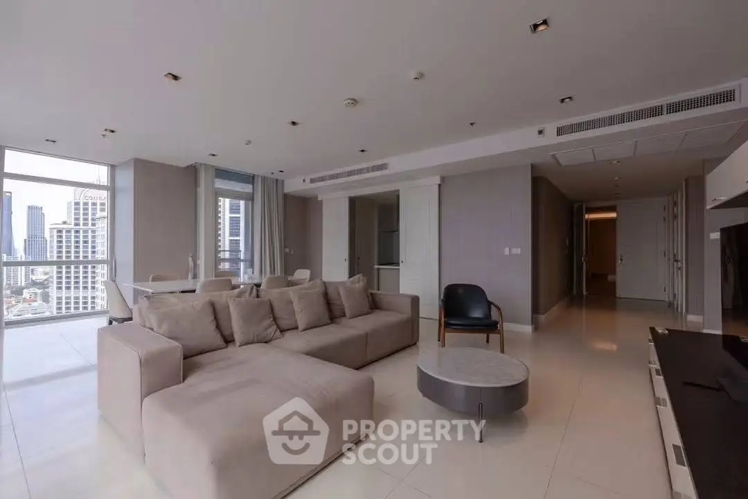 Spacious modern living room with city view and elegant furnishings in a high-rise apartment.