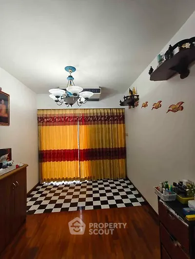 Charming living room with elegant chandelier and checkered floor, perfect for cozy gatherings.