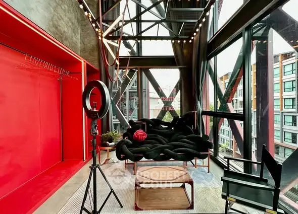 Modern industrial-style living room with large windows and unique furniture.