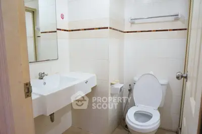 Modern bathroom with sleek white fixtures and tiled walls