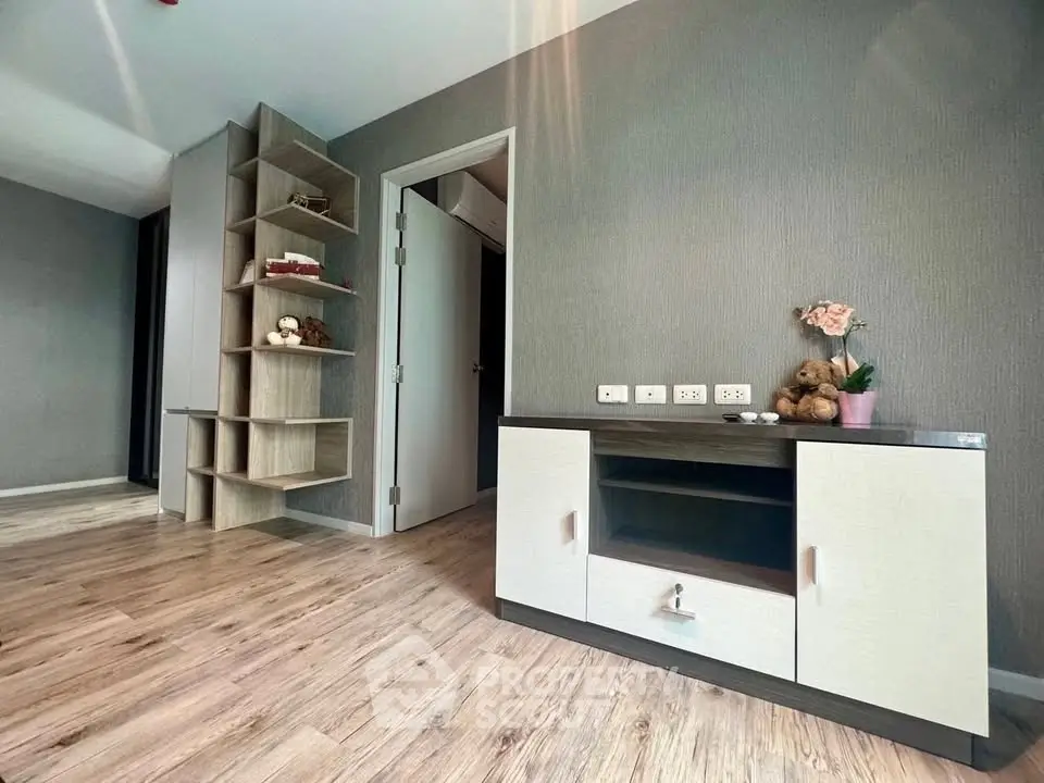 Modern living room with stylish wooden flooring and built-in shelving, perfect for cozy home decor.