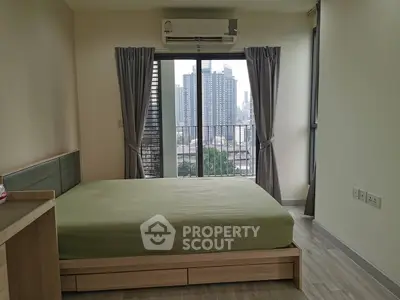 Modern bedroom with city view and balcony access in high-rise apartment