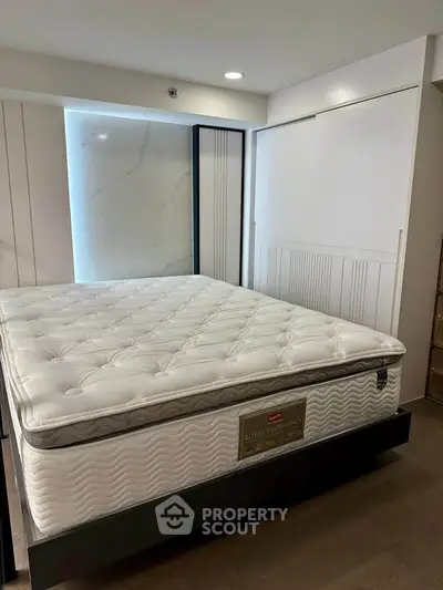 Spacious bedroom with luxurious mattress and modern design elements.