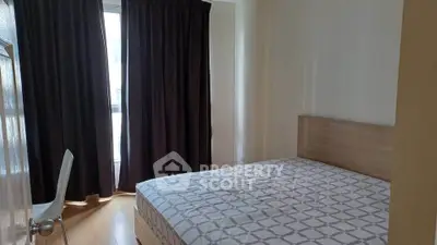 Cozy bedroom with natural light and modern furnishings in a stylish apartment.