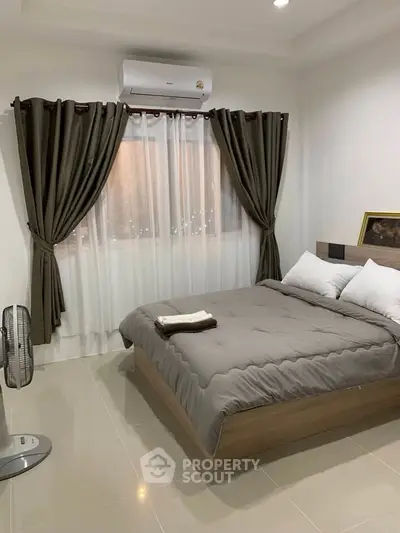 Cozy bedroom with modern decor and air conditioning, perfect for relaxation.
