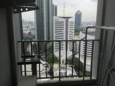 Stunning cityscape view from a high-rise balcony overlooking modern skyscrapers and urban landscape.