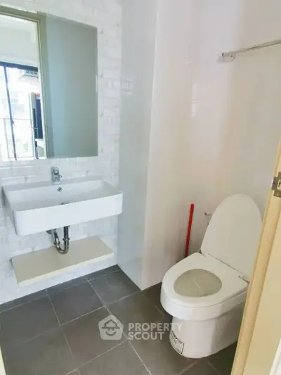 Modern bathroom with sleek fixtures and large mirror in a bright apartment.