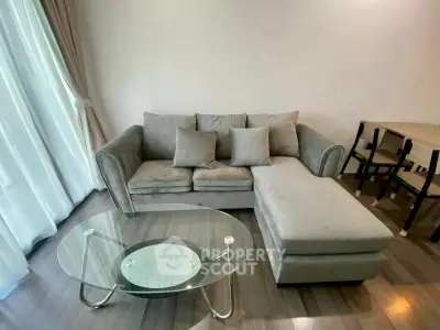 Modern living room with plush gray sofa and glass coffee table, perfect for relaxation.