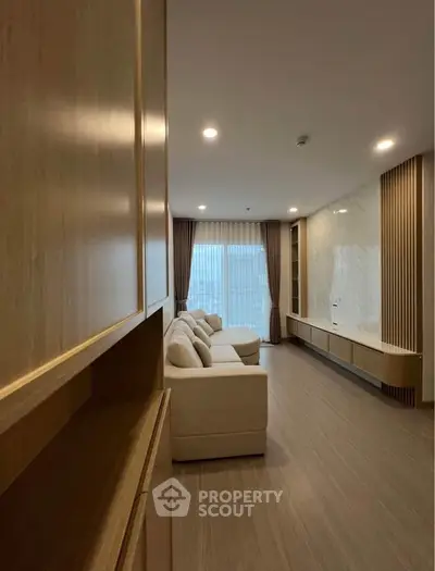 Spacious modern living room with elegant wood finishes and large windows for natural light.