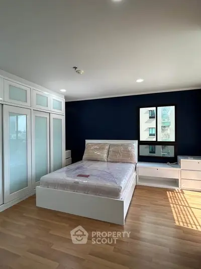 Spacious bedroom with modern design and large windows offering natural light.