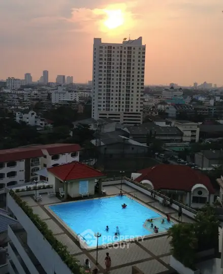 Stunning rooftop pool with city skyline view at sunset, perfect for urban living.