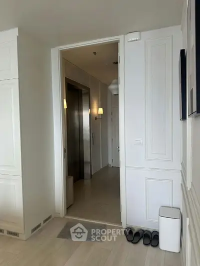 Modern apartment entrance with sleek elevator access and stylish interior design.