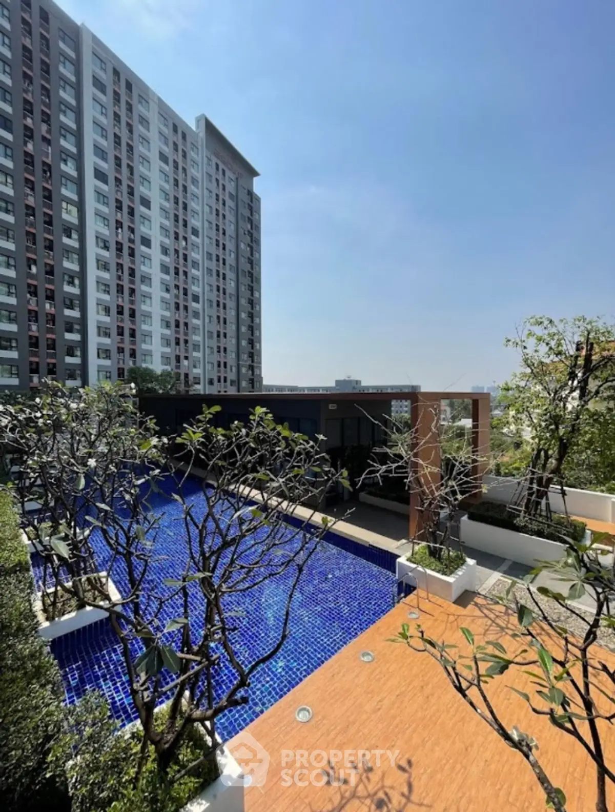 Luxurious high-rise building with stunning pool and lush greenery, perfect for urban living.