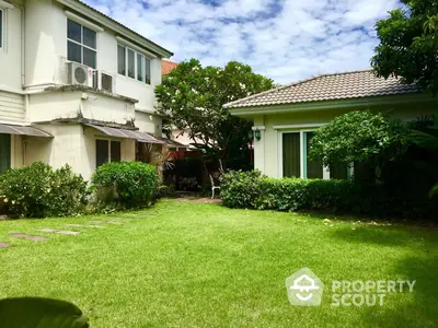 Charming family home with lush green lawn and mature landscaping, featuring a spacious backyard perfect for outdoor activities and relaxation.