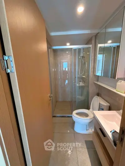Modern bathroom with glass shower and sleek fixtures in a contemporary apartment.