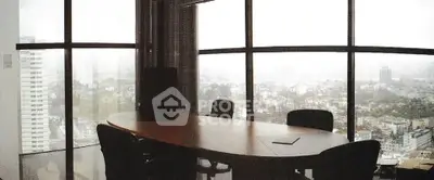 Spacious office meeting room with panoramic city view and large windows.