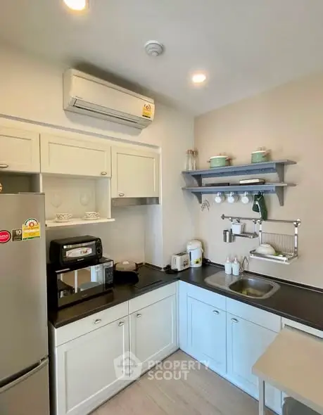 Charming kitchen with modern appliances and sleek cabinetry in cozy apartment.